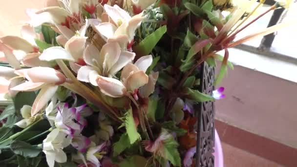 Színes mesterséges virágok a teraszon kert műanyag vödör és kosár - Felvétel, videó
