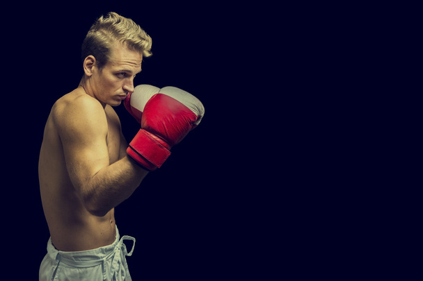 Nuori mies nyrkkeilijä tummalla taustalla
 - Valokuva, kuva