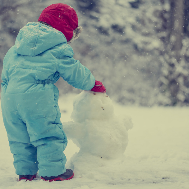 Giovane bambino che costruisce un uomo delle nevi
 - Foto, immagini