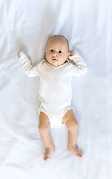 Novorozené dítě leží na bílé posteli. Selektivní soustředění. Lidé. - Fotografie, Obrázek