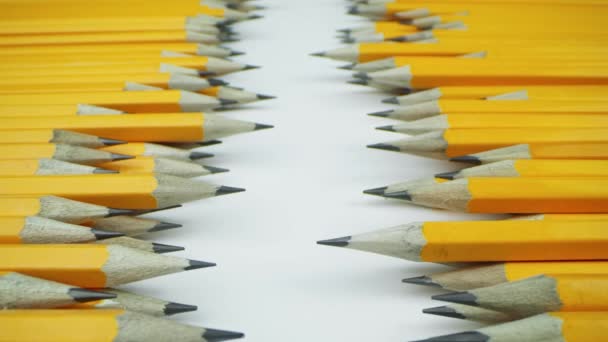 Lápices amarillos se encuentran al azar sobre un fondo blanco - Metraje, vídeo