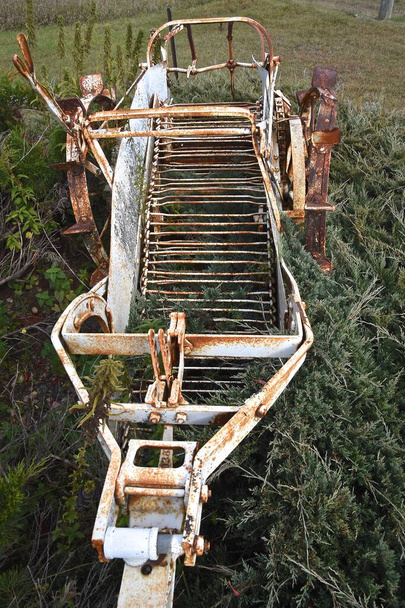 Un viejo recolector de papas oxidado dejado fuera en una pila de pincel, (vista aérea) - Foto, Imagen