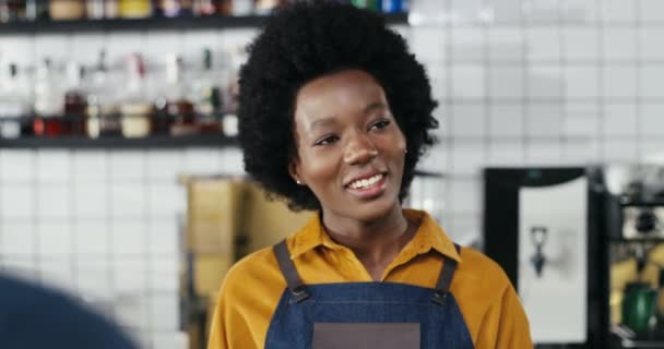 Kafkasyalı çiftten sipariş alan gülümseyen Afro-Amerikan bayan barmen. Müşterilerin arkası. Karışık ırklar. Müşteriler kahve alıyor ve kafede garsonla konuşuyor. Çoklu Etnik. - Video, Çekim