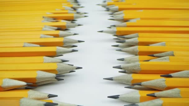 Lápices amarillos se encuentran al azar sobre un fondo blanco - Metraje, vídeo