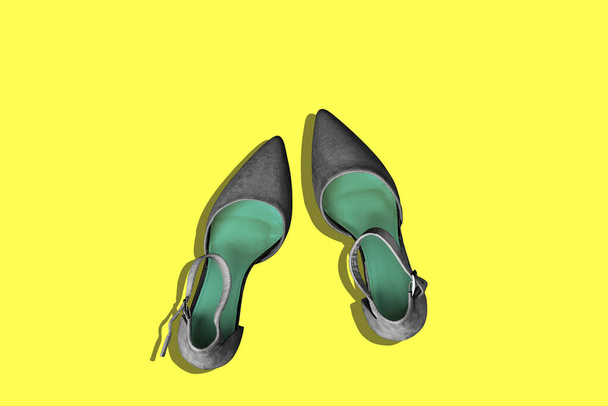 Czarne damskie buty na żółtym tle z kopią przestrzeni. Blog dla kobiet. Widok z góry, płaski układ - Zdjęcie, obraz