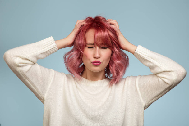 Portrait of a beautiful woman with pink hair on a blue background - Photo, Image