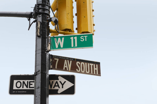 Street signs on the corner of 7th Ave South and West 11th Street in Greenwich Village, New York City; copy space on blue sky - Photo, Image