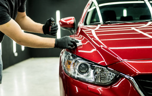 Car service worker applying nano coating on a car detail. - Foto, afbeelding