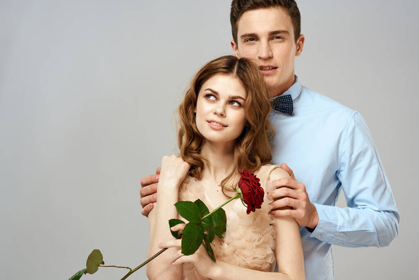 Fiatal pár ölelés romantika társkereső életmód kapcsolat fény háttér piros rózsa - Fotó, kép