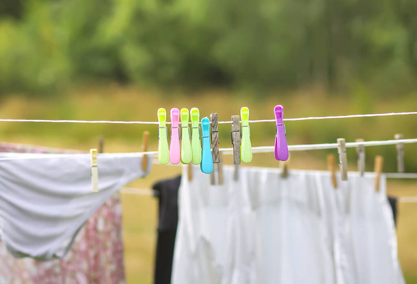 Colorida ropa colgada de la cuerda al aire libre. El proceso de secado al aire ropa - Foto, Imagen