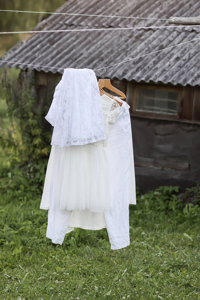 Suknie bielizny wiszące na drewnianych wieszakach na świeżym powietrzu w letni dzień - Zdjęcie, obraz