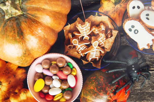 fresh pumpkin, halloween cookies, Halloween Jack o Lantern pumpkin, candy and halloween Trick or Treat on black wooden background - Foto, Bild