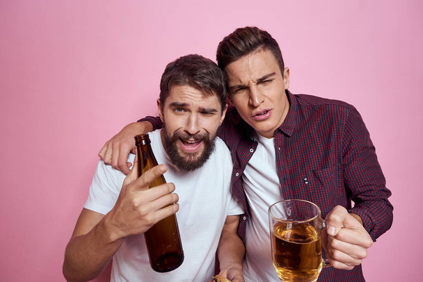 Двоє чоловіків п'ють пиво дружба п'яний алкогольний спосіб життя рожевий фон
 - Фото, зображення