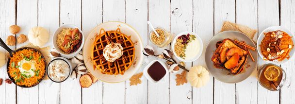 Осенний завтрак или завтрак "шведский стол" сцена на белом фоне баннера дерева. Тыквенные оладьи, вафли, яблочные французские тосты, овсянка, яичная сковорода, йогурт. Вид сверху. - Фото, изображение