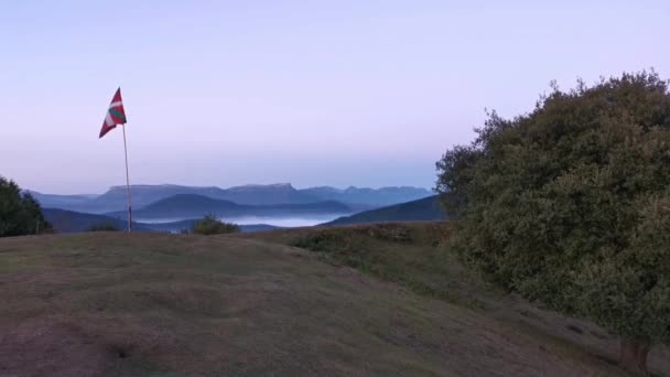 Bandera del País Vasco ondeando en la cima de una montaña.Fondo cielo azul - Metraje, vídeo