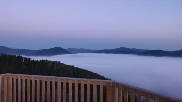 Zonsopgang uitzicht op zee wolken die de vallei met silhouetten van de bergen opdoemen in de achtergrond - Video