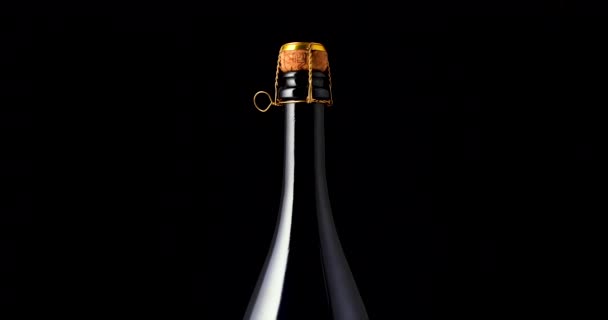 Botella de champán de primer plano sobre fondo negro. Imágenes de vídeo en cámara lenta 360, 4K UHD - Imágenes, Vídeo