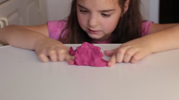 Ośmioletnia dziewczynka bawi się toffi śluzem popularnej rozrywki wśród dzieci - Materiał filmowy, wideo