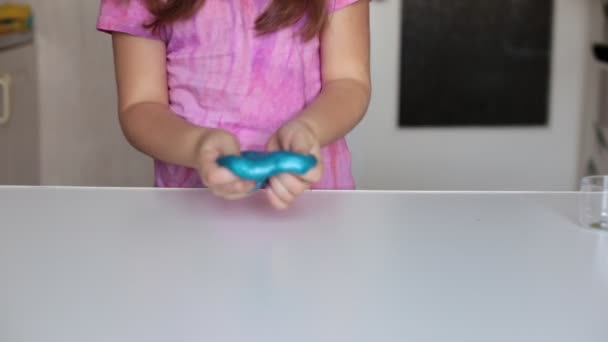 Ocho años de edad, niña juega con el limo toffee entretenimiento popular entre los niños - Metraje, vídeo