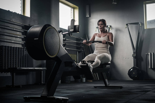 Strong Woman Finishes Training on Rowing Machine . - Photo, Image