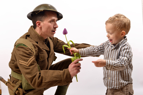 un jeune enfant donne une fleur à un soldat britannique
 - Photo, image