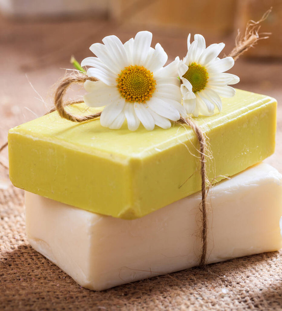 自家製カモミール石鹸。白と黄色の手作りの石鹸バーのクローズアップビュー。天然の健康的なハーブ化粧品 - 写真・画像