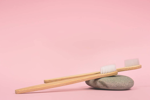 bamboo tooth brushes on a stone pink background place for text - Photo, image
