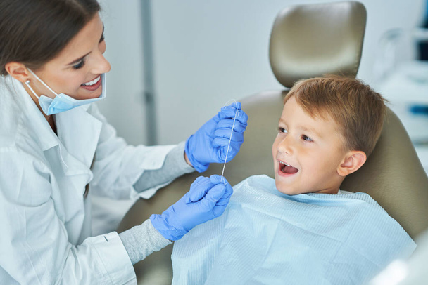 Mały chłopiec i kobieta dentysta w gabinecie dentystycznym - Zdjęcie, obraz
