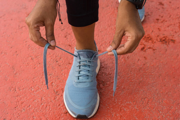 Női futó, aki beköti a cipőfűzőjét futás előtt - Fotó, kép
