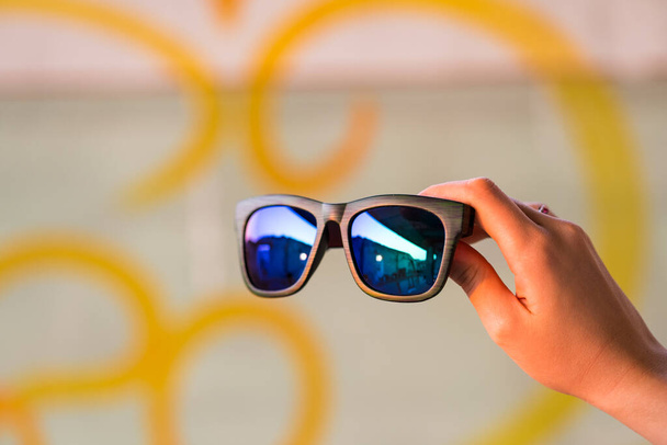 Klasyczny model okularów przeciwsłonecznych trzymać ręcznie w letni dzień zbliżenie. Skupienie selektywne - Zdjęcie, obraz