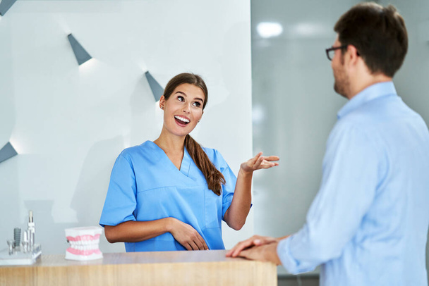 Pacjent opłacający wizytę stomatologiczną w klinice - Zdjęcie, obraz