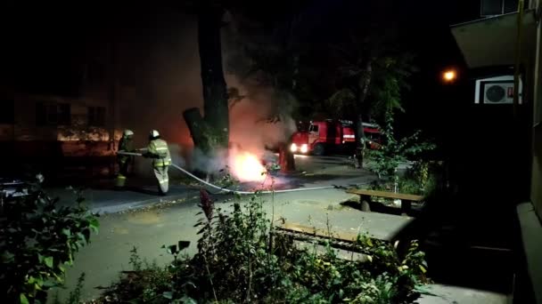 Bombeiros extinguem carro posto por vândalos dele há uma fumaça forte em uma área residencial - Filmagem, Vídeo