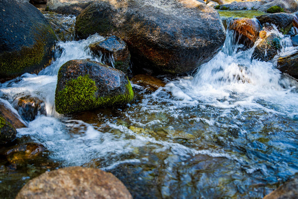  churning white water flowing around large rocks in mountain stream of California - Фото, изображение