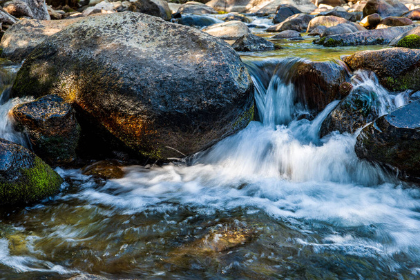  agitando a água branca que flui em torno de grandes rochas no córrego da montanha da Califórnia - Foto, Imagem