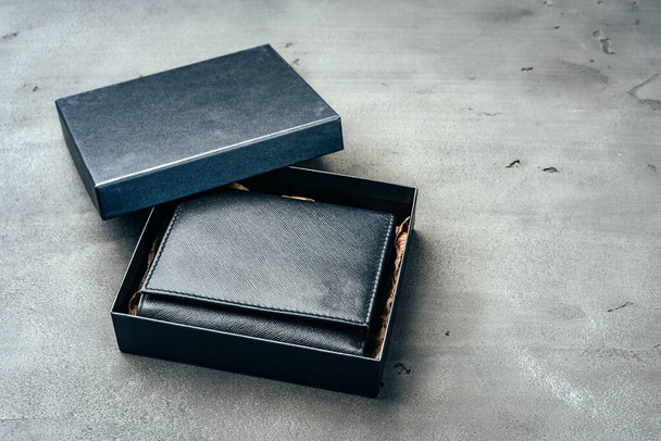 Black leather wallet on grey concrete background - Fotoğraf, Görsel