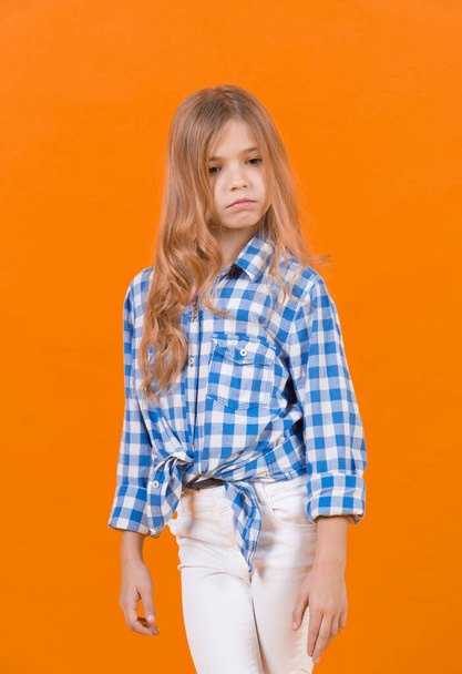 Child pose in shirt and pants on orange background - Fotoğraf, Görsel