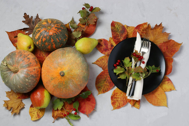 Tafelopstelling op Thanksgiving Day versierde pompoen, viburnum, peren en kleurrijke bladeren op grijs. Bovenaanzicht - Foto, afbeelding