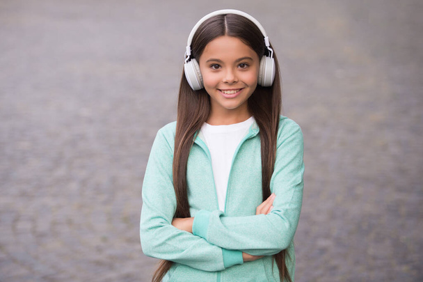 cheerful child wear earphones with music song outdoor enjoying melody, back to school - Fotografie, Obrázek