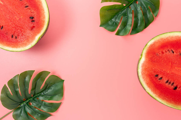 Watermelon with palm tree leaf on pink background. Creative minimal summer concept. - Foto, afbeelding