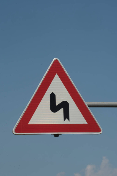 道路上のカーブや交通標識を警告として - 写真・画像