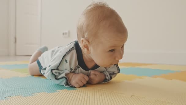 Pequeño niño arrastrándose sobre la alfombra - Metraje, vídeo
