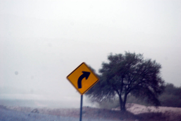 кривая на дороге и дорожный знак как предупреждение - Фото, изображение