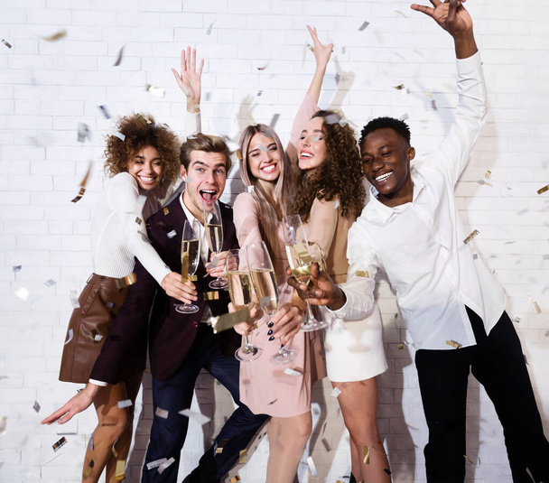 Multiculturale amici festa avendo divertimento con champagne e confetti indoor - Foto, immagini