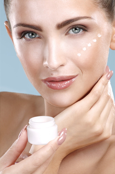 Beautiful woman applying cream treatment on her perfect face - Foto, Bild