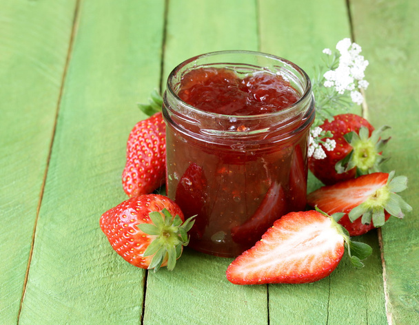 Erdbeermarmelade mit frischen Beeren im Glas auf dem Tisch - Foto, Bild