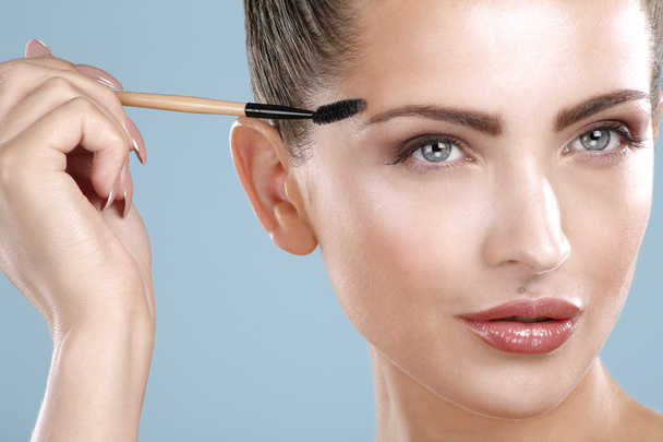 Closeup beautiful woman with eyebrow brush tool - Фото, зображення