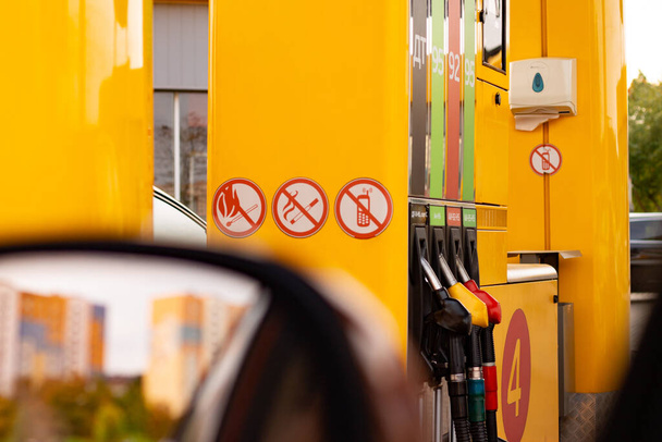 Жовтий дозатор на АЗС з різними типами бензину, вид з вікна автомобіля
 - Фото, зображення