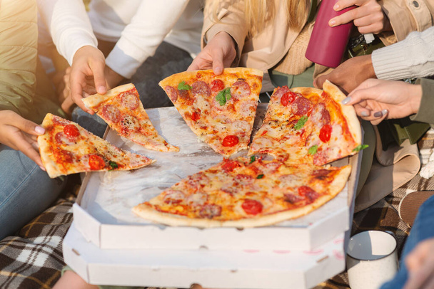 Internationale groep vrienden die pizza 's pakken - Foto, afbeelding