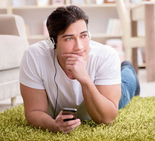 Młody student słuchający muzyki w domu - Zdjęcie, obraz