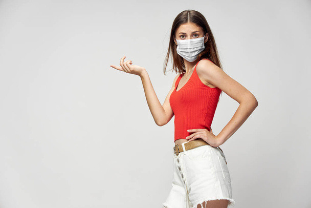 Mulher em máscara protetora contra coronavírus posando em estúdio. - Foto, Imagem